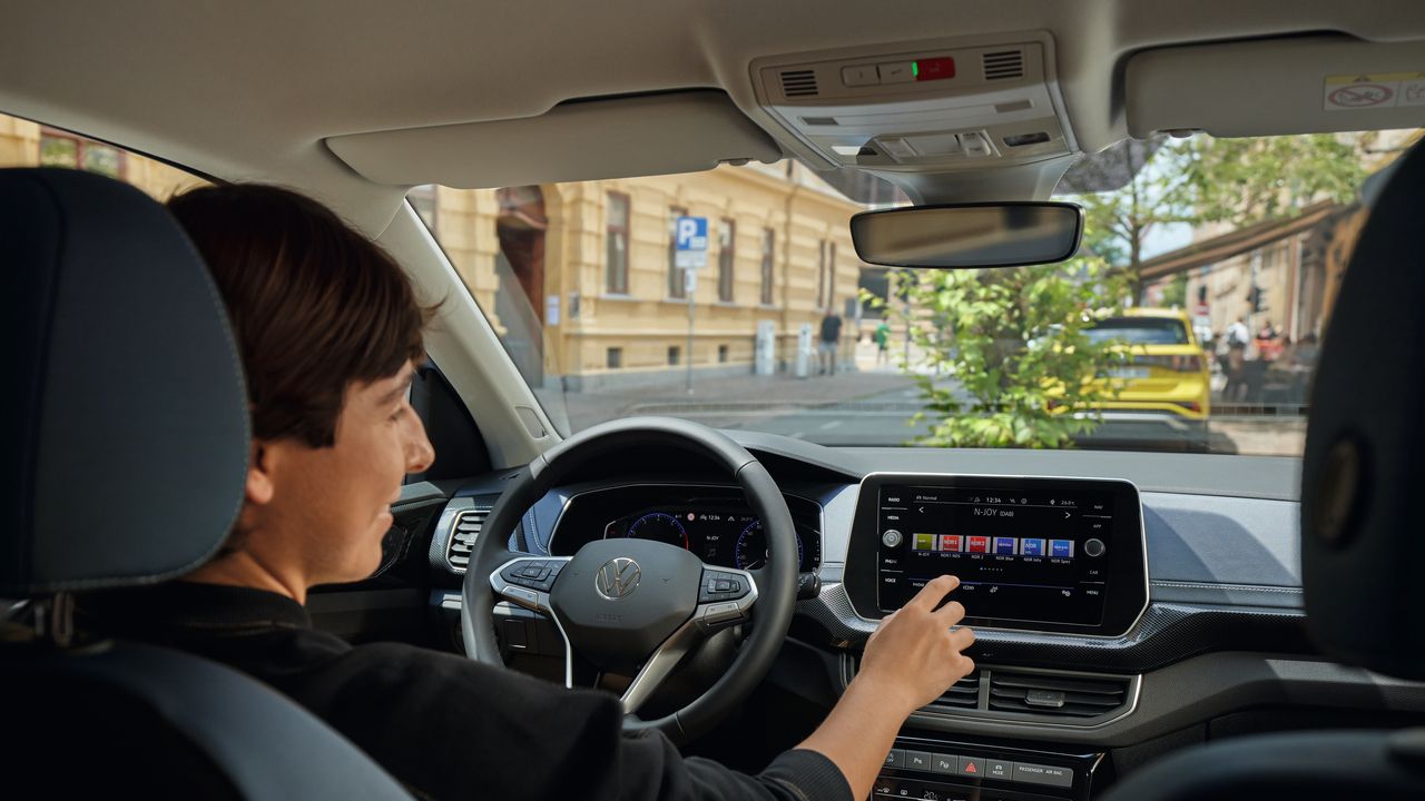 Eine Person nutzt das Infotainment-Display im VW T-Cross.