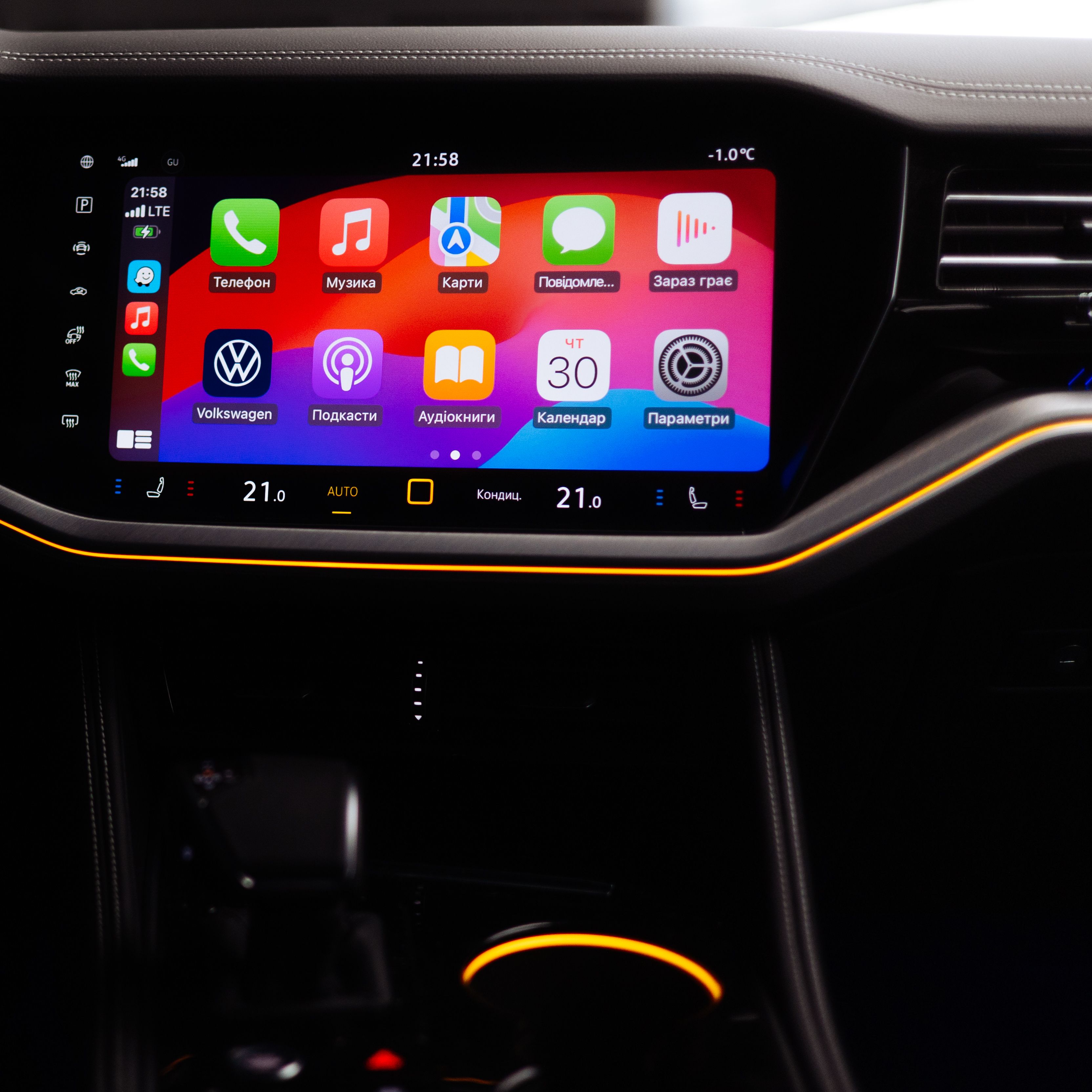 Ein Mann in einem parkenden VW Touareg Elegance verbindet sein Smartphone per Wireless App Connect mit dem VW Touareg Elegance.