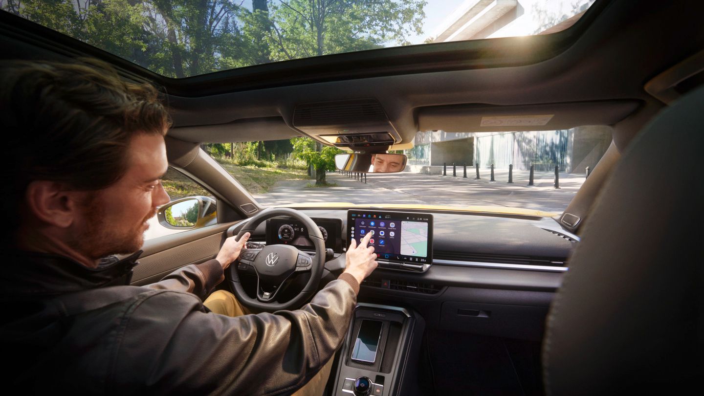 VW T-Roc Ein Mann bedient auf dem Infotainment-Display in seinem Volkswagen T-Roc Android Auto über die App-Connect Schnittstelle.