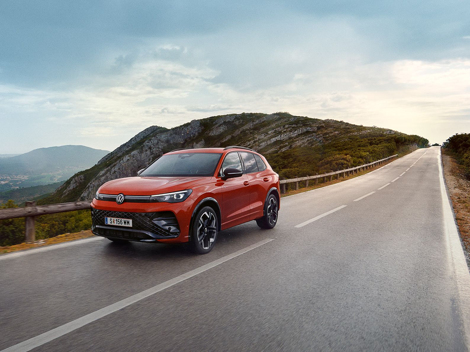 Roter VW Tiguan fährt eine Straße entlang.